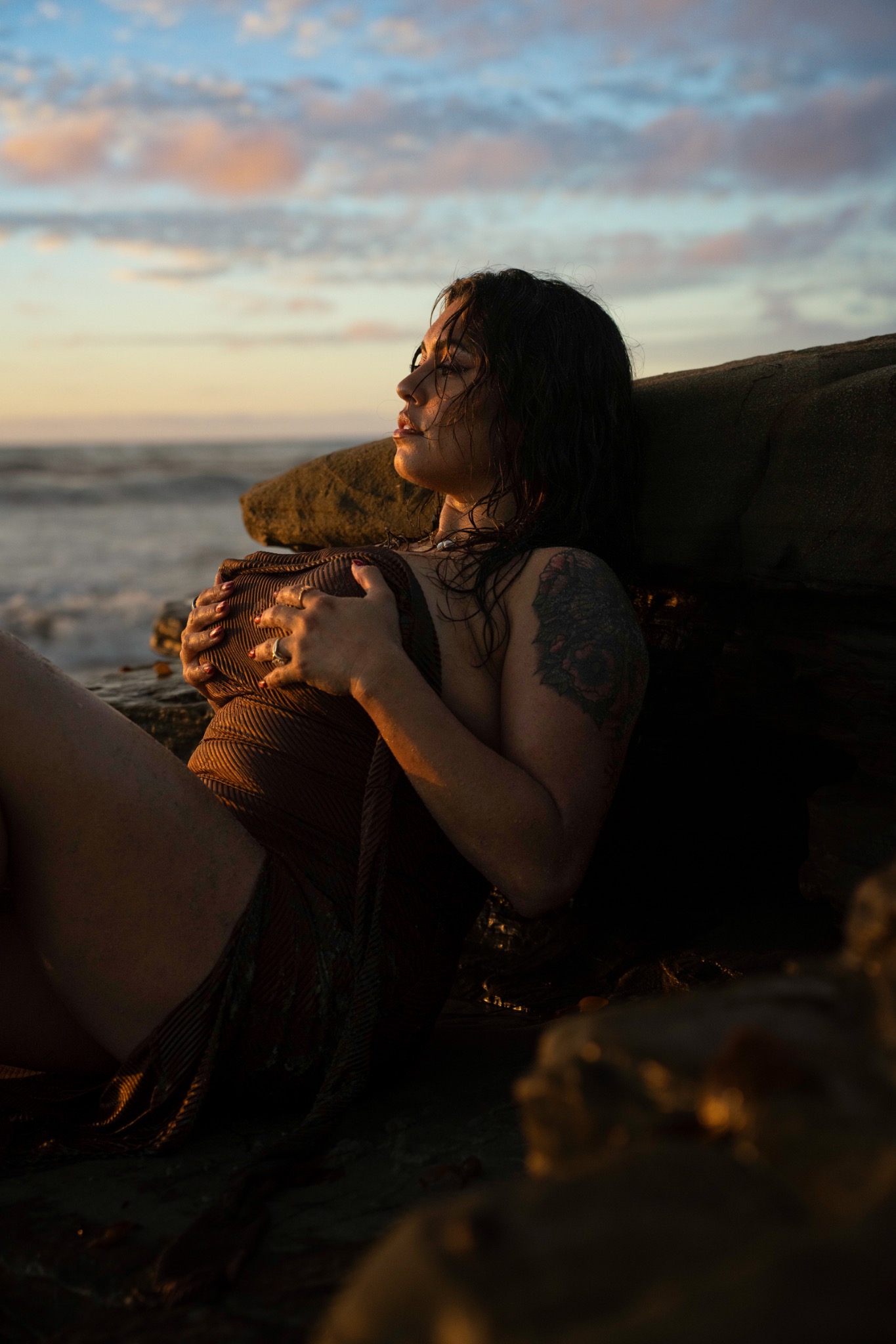Golden-hour portrait beside coastal rocks